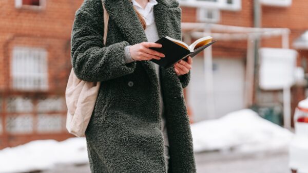 crop student reading book in winter town