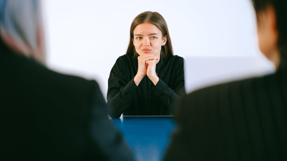 woman in black blazer sitting being interview