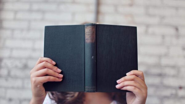 selective focus photography of woman holding book