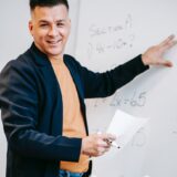 photo of man discussing on white board