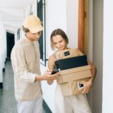 a woman receiving her parcels while standing beside the delivery man