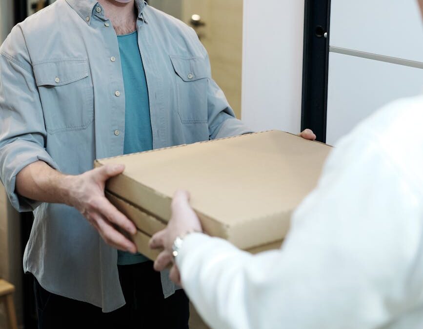 man wearing a face mask receiving a pizza delivery