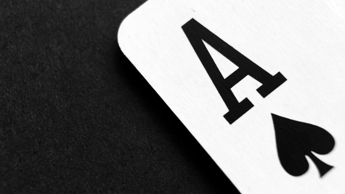 ace of spade playing card on grey surface