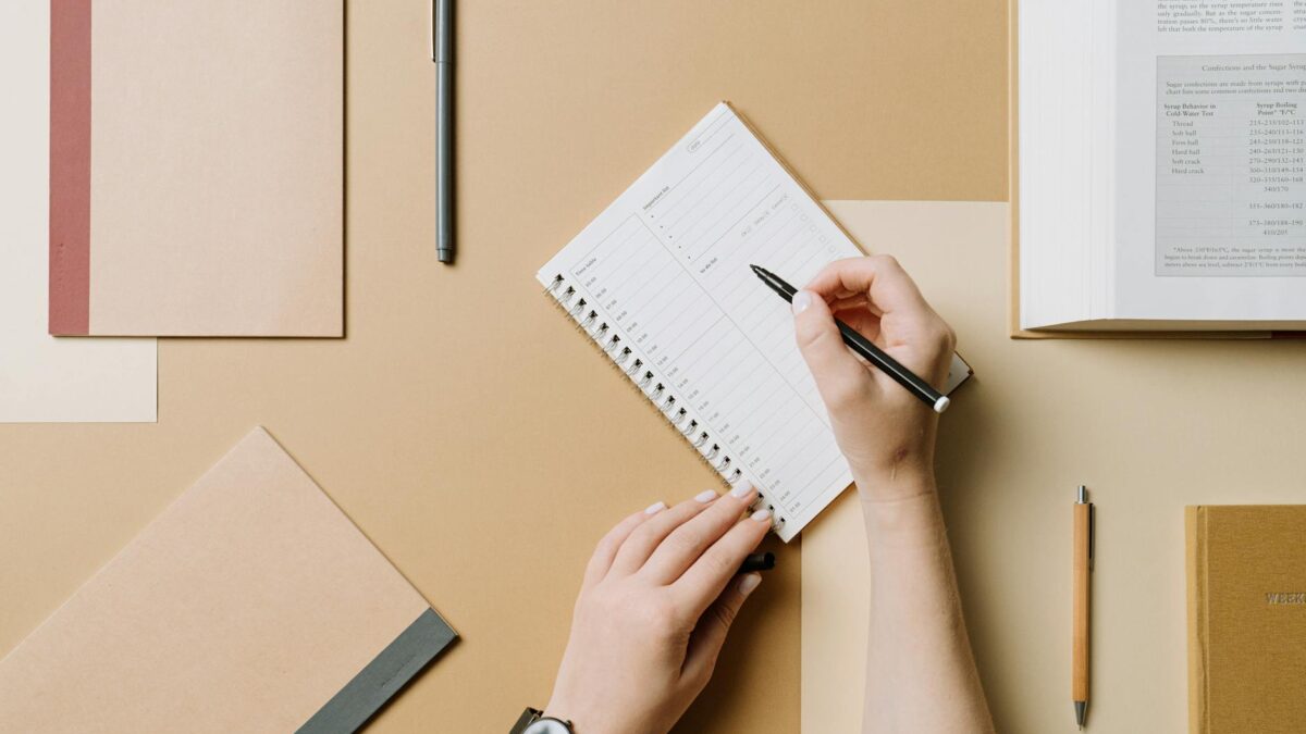 top view of woman writing in a planner