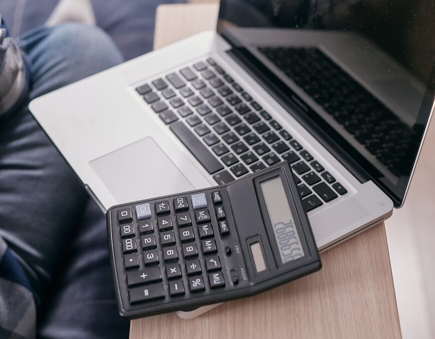 a laptop and calculator on a wooden table