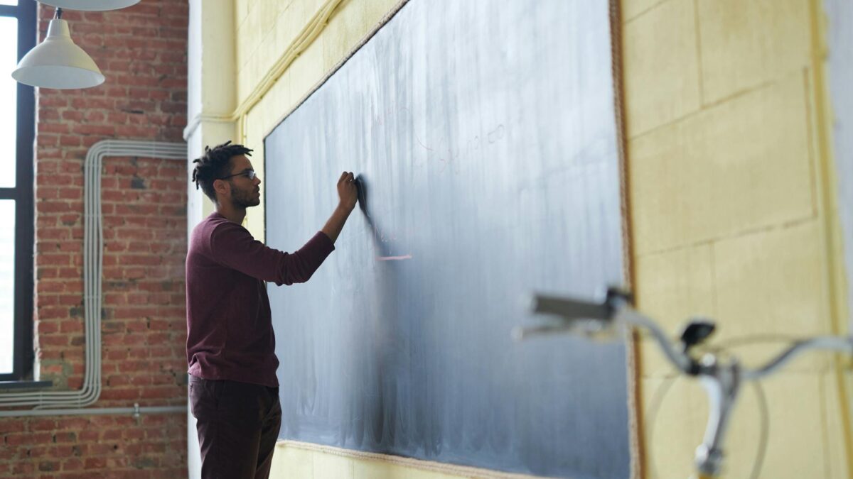 man writing on a blackboard