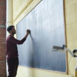 man writing on a blackboard