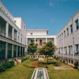 green trees between white concrete buildings