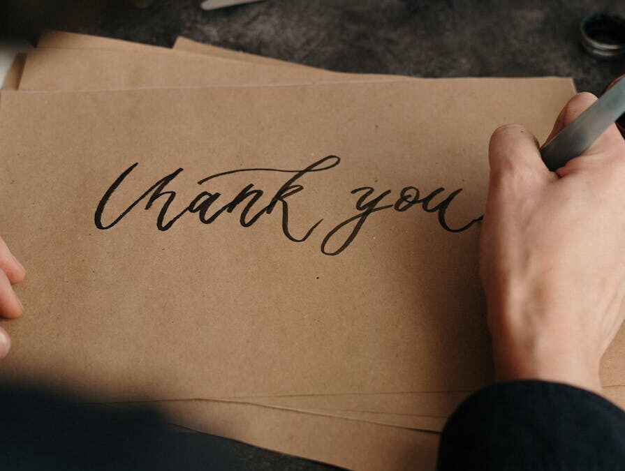 person writing on brown printer paper