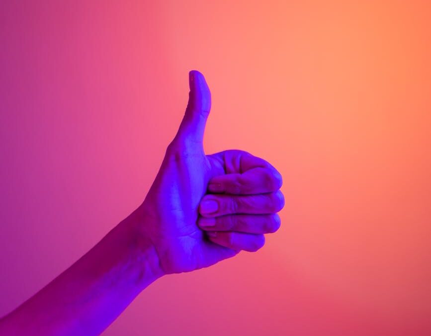 persons hand doing thumbs up